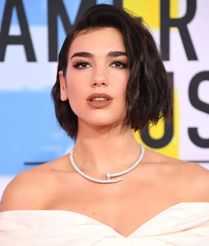 a photo of dua lipa wearing a side part' fetchpriority='auto' title='Trend Alert: Two Hairstylists Spill the Tea on the Buzzy Apple Haircut
