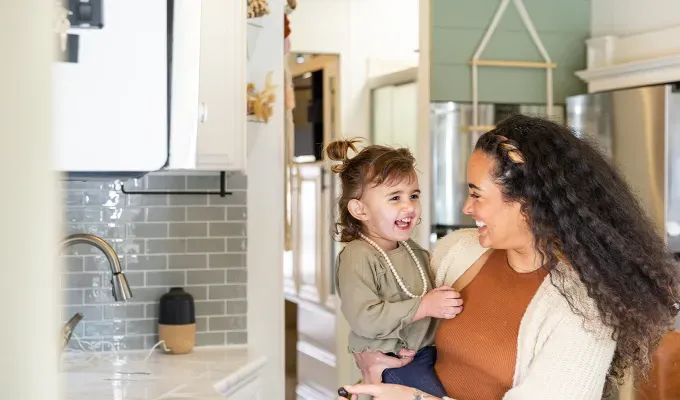 realistic-daily-schedules-for-kids: a mom holding a toddler' fetchpriority='auto' title='5 Realistic Daily Schedules for Kids From Ages 0 to 11 According to Experts