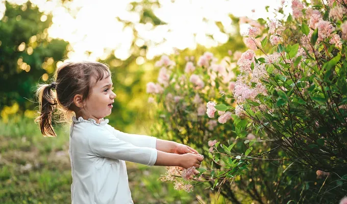 italian bellissima baby girl names a little girl playing with a flower bush' fetchpriority='auto' title='75 Bellissima Italian Baby Girl Names