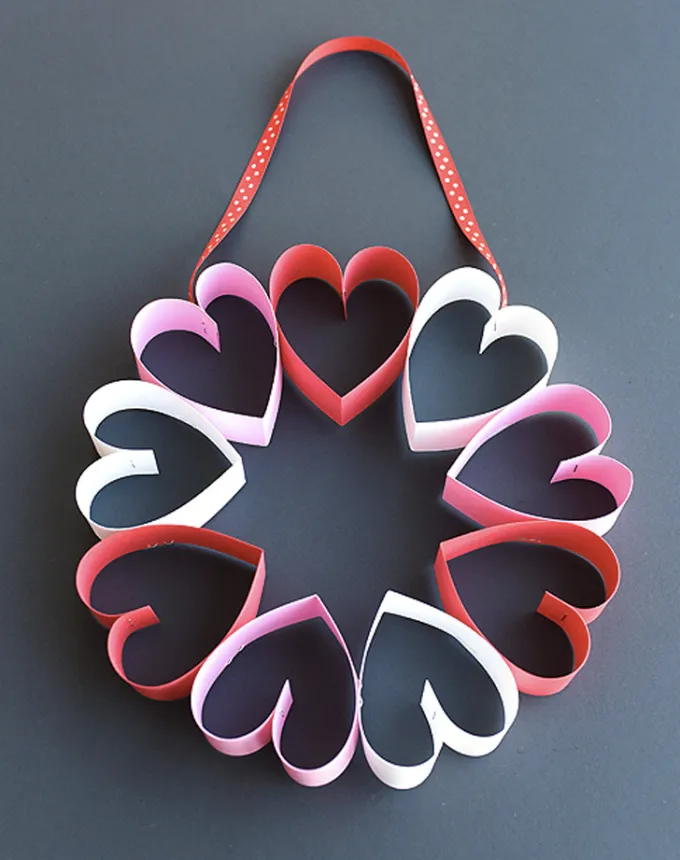 52 Fun and Easy Valentine’s Day Crafts for Kids - 3D hearts are affixed together in a circle to create a wreath.' title='70 Fun and Easy Valentine’s Day Crafts for Kids