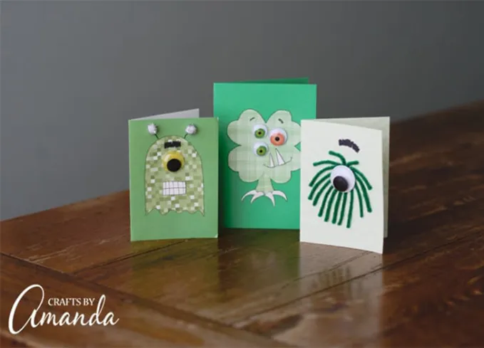 st patricks day crafts for kids: DIY green monster cards on a table' title='30 Fun and Easy St. Patrick’s Day Crafts for Kids