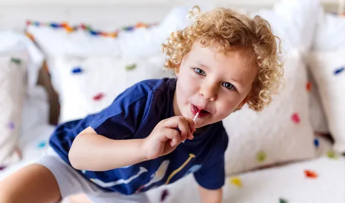 Portrait of happy little boy with lollipop on the couch' fetchpriority='auto' title='100 Baby Names That Mean Star