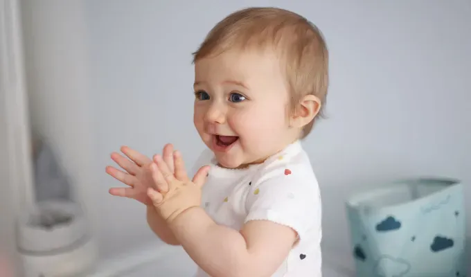 A 1 year old baby girl clapping her hands on her baby-changing table' fetchpriority='auto' title='100 Baby Names That Mean Star