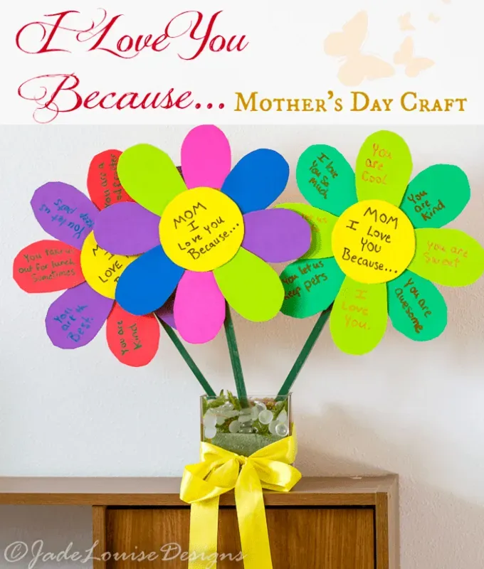 mothers-day-crafts: A papercraft made in the shape of flowers with handwritten notes on the petals. They are positioned in a glass vase on a wooden table.' title='45 Mother’s Day Crafts for Kids That She’ll Actually Want to Keep