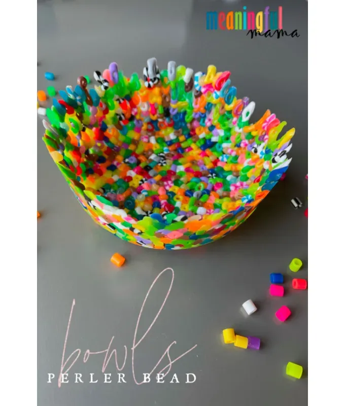 mothers-day-crafts: A colorful melted Perler bead bowl on a gray table with extra beads scattered on it.' title='45 Mother’s Day Crafts for Kids That She’ll Actually Want to Keep
