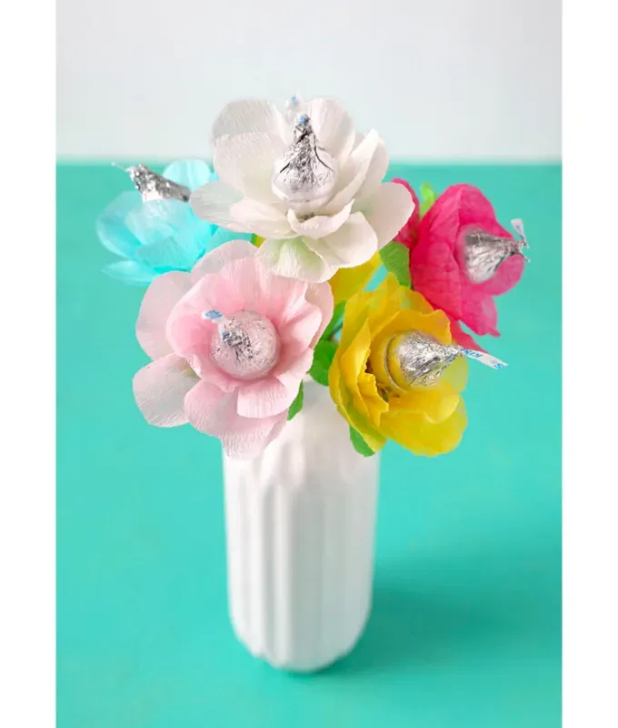 mothers-day-crafts: A white vase filled with crepe paper flowers with Hershey kiss centers.' title='45 Mother’s Day Crafts for Kids That She’ll Actually Want to Keep