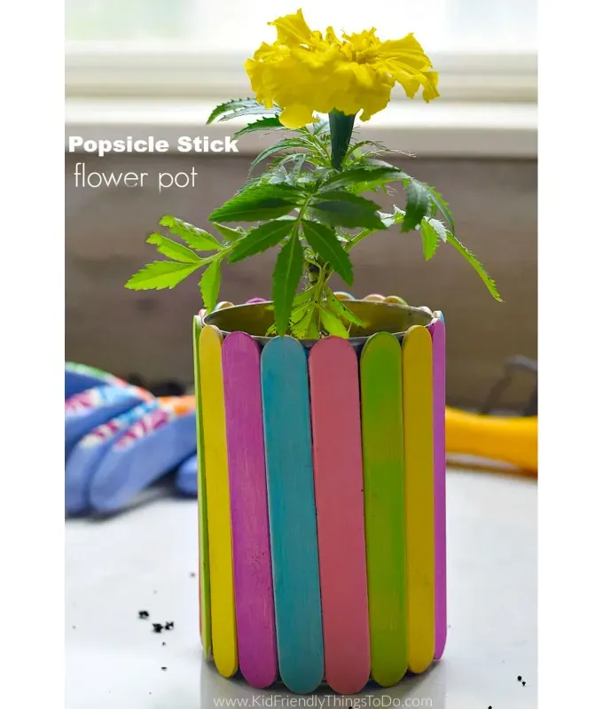 mothers-day-crafts: A colorful popsicle stick vase with a yellow flower in it.' title='45 Mother’s Day Crafts for Kids That She’ll Actually Want to Keep