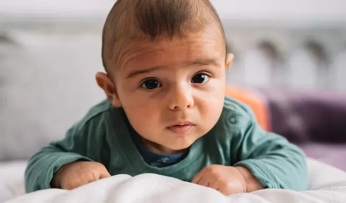 names-that-mean-fire: a baby laying on their stomach.' fetchpriority='auto' title='100 Baby Names That Mean Fire Perfect for the Formidable Bun in Your Oven