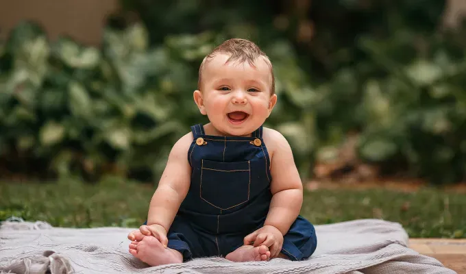 names-that-mean-fire: a baby wearing overalls.' fetchpriority='auto' title='100 Baby Names That Mean Fire Perfect for the Formidable Bun in Your Oven