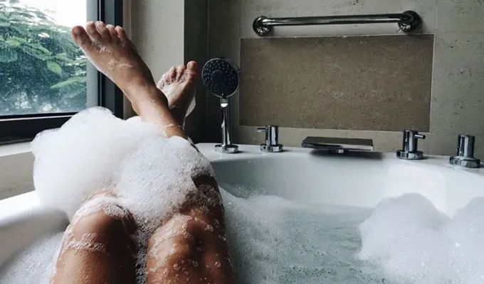 things-to-do-when-you’re-bored: A person’s legs covered in bubbles popped out of a bathtub.' fetchpriority='auto' title='Wondering What to Do When You’re Bored? Here Are 105 Fun Things to Do for Any Mood