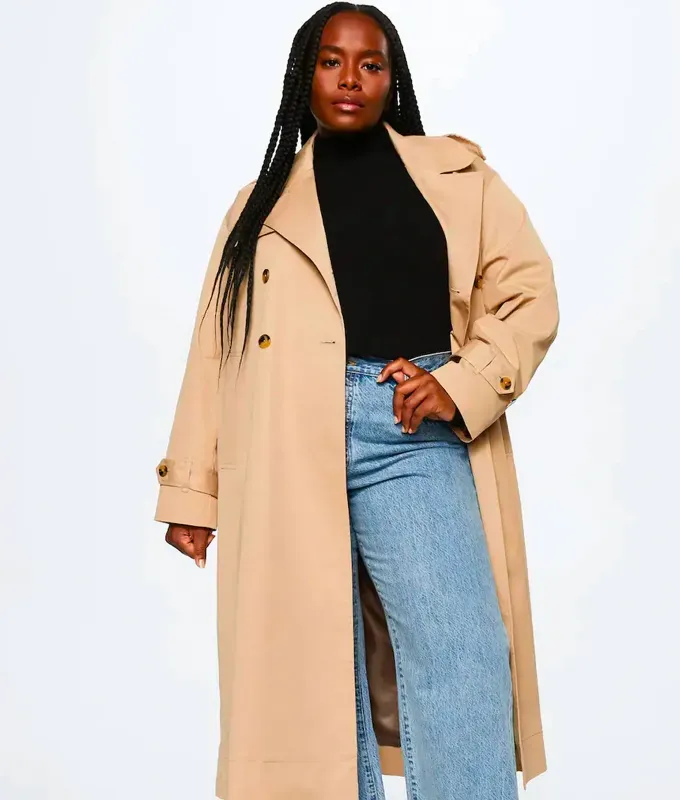 Stores Like Lulus: woman in camel trench coat black high-neck top and blue jeans from Mango' title='20 Stores Like Lulus to Shop Right Now