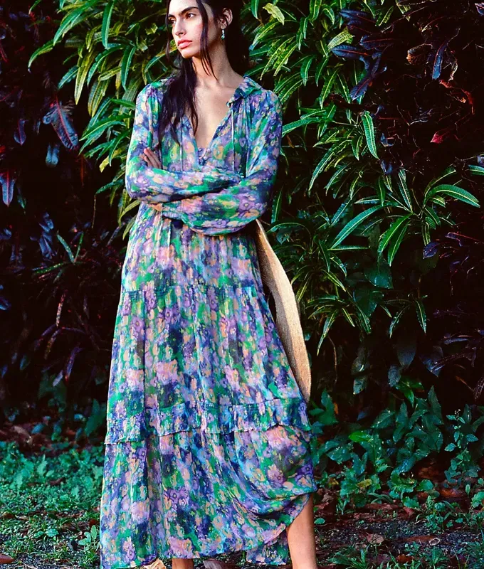 Stores Like Lulus: woman wearing a long sleeve flowy printed dress from Anthropologie' title='20 Stores Like Lulus to Shop Right Now