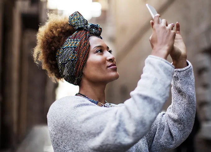 woman wearing a rosie the riverter type head scarf style' fetchpriority='auto' title='13 Head Scarf Styles for Bad Hair Days and Beyond