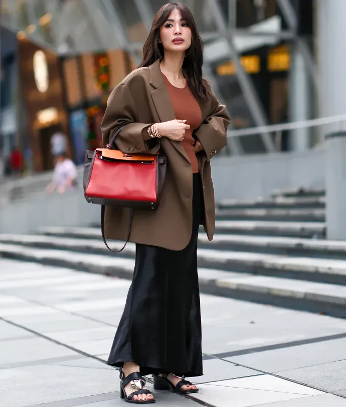woman-wearing-a-long-black-slip-skirt-with-a-brown-blazer' fetchpriority='auto' title='22 Easy Black Skirt Outfit Ideas for When You Have Five Minutes to Get Dressed