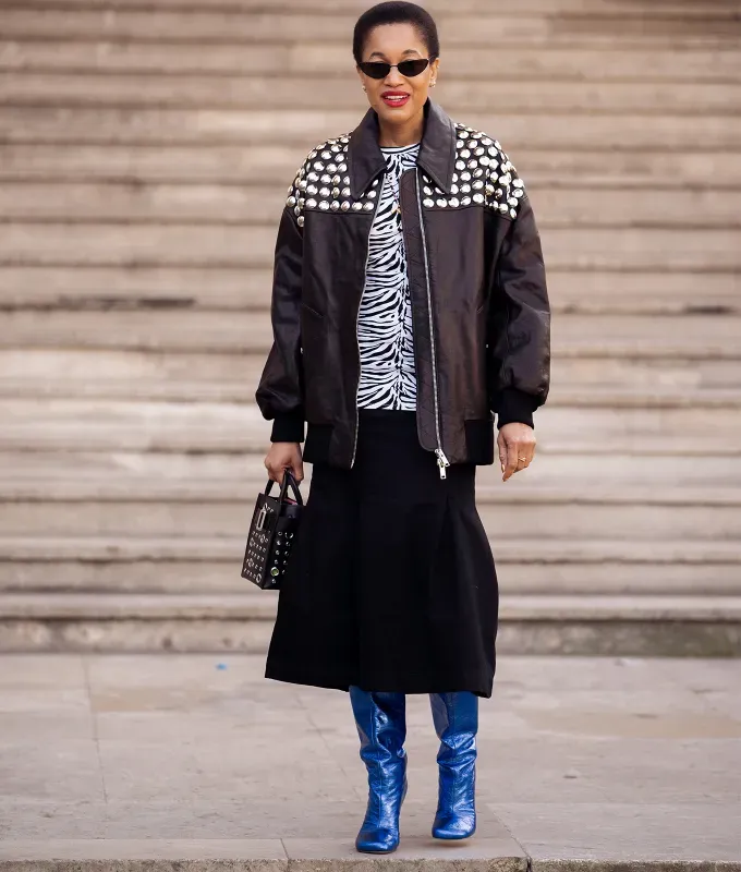woman wearing a zebra shirt and black midi skirt with blue metallic boots' fetchpriority='auto' title='22 Easy Black Skirt Outfit Ideas for When You Have Five Minutes to Get Dressed