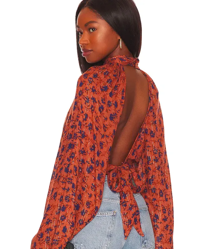 stores like hm revolve. Model showing off an open back blouse and blue jeans.' title='16 Stores Like H&M to Shop Right Now