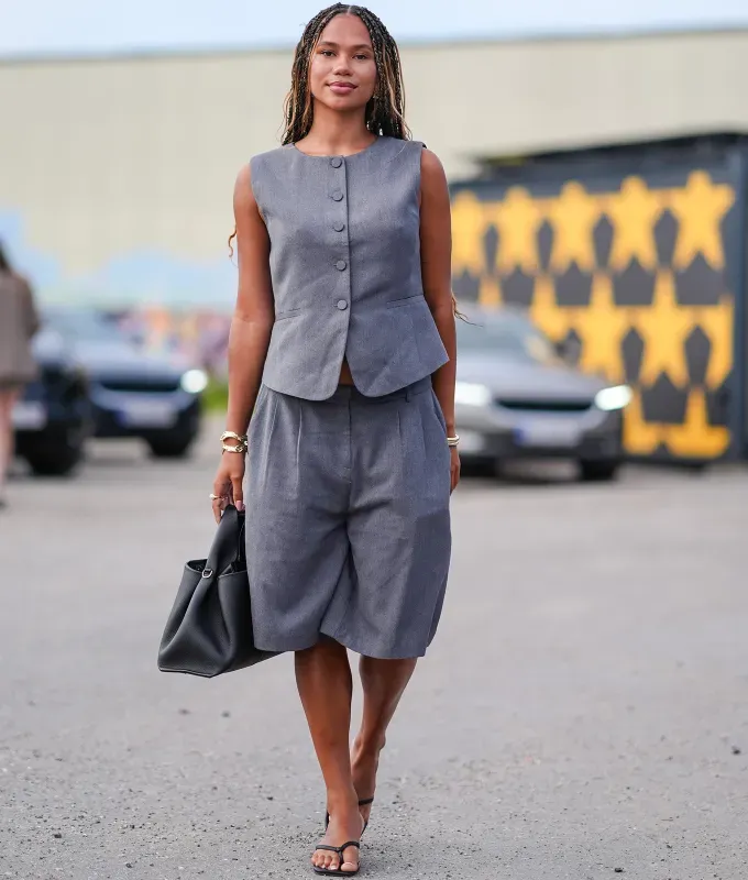 woman wearing a vest and matching bermuda shorts' fetchpriority='auto' title='How to Wear a Vest in 2025 (Plus One Look That’s Best Left in 2007)