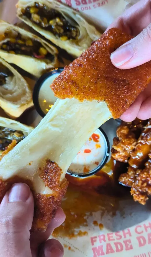 chili’s nashville hot mozz torn apart showing cheese inside' fetchpriority='auto' title='Psst: The Best App at Chili’s Isn’t *Actually* on the Menu