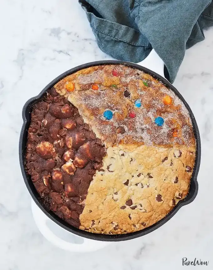 fun things to bake: aerial of a skillet cookie split into snickerdoodle chocolate chip and s’mores varieties' title='78 Easy Fun Things to Bake When You’re Bored and Craving Something Sweet