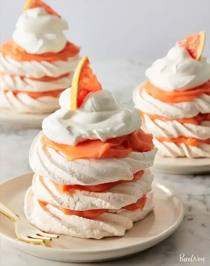 fun things to bake: three grapefruit meringue stacks topped with whipped cream and a slice of grapefruit' title='78 Easy Fun Things to Bake When You’re Bored and Craving Something Sweet