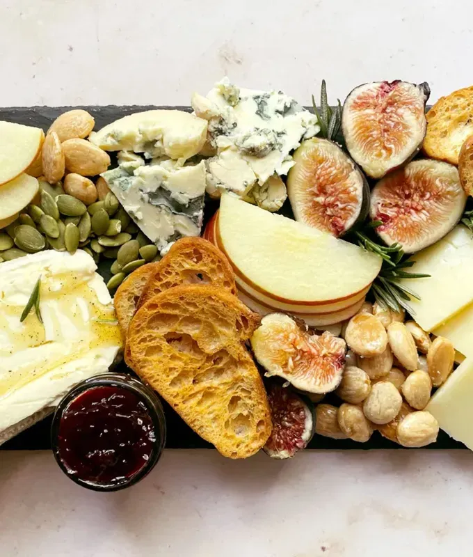 best appetizers to bring to a party: fall charcuterie board with black pepper honey brie figs and rosemary' title='The 25 Best Appetizers to Bring to a Party from Crowd-Pleasing Dips to Make-Ahead Snacks