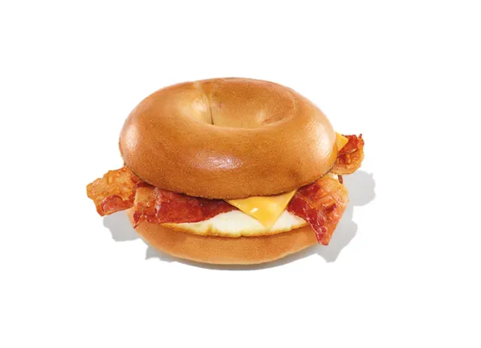 Keto at Dunkin Donuts - A plain bagel bacon egg and cheese from Dunkin on a white background.' title='How to Eat Keto at Dunkin’ Donuts: 15 Low-Carb Foods and Drinks We Love