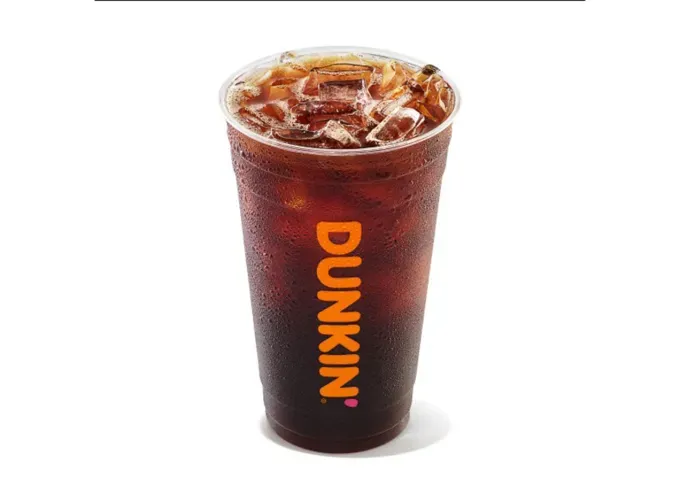 Keto at Dunkin Donuts - A clear Dunkin cup full of cold brew in front of a white background.' title='How to Eat Keto at Dunkin’ Donuts: 15 Low-Carb Foods and Drinks We Love