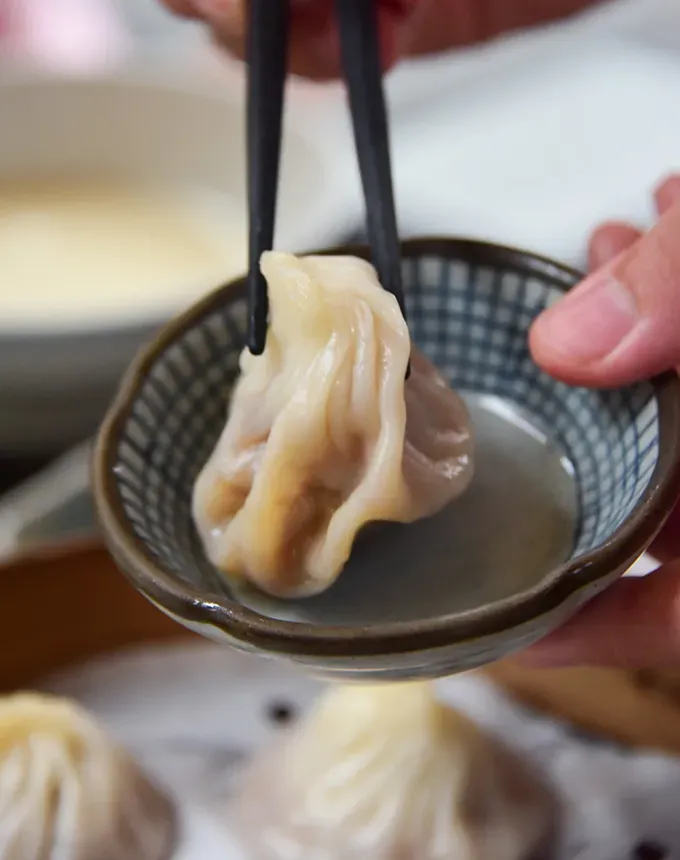 traditional chinese foods: soup dumpling in a bowl being held with chopsticks' title='20 Traditional Chinese Food Dishes You Need to Try According to a Chinese-Malaysian Chef