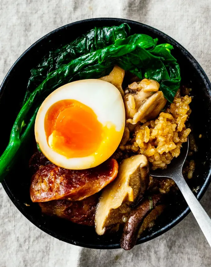 traditional chinese foods: aerial view of chinese sticky rice with greens and jammy egg' title='20 Traditional Chinese Food Dishes You Need to Try According to a Chinese-Malaysian Chef