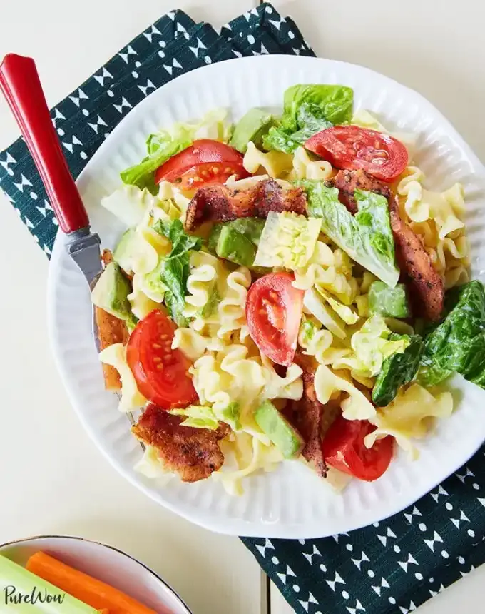 easy lunch ideas: plate of BLT pasta salad atop a blue linen' title='82 Easy Lunch Ideas That Are Fast Low-Fuss and Foolproof