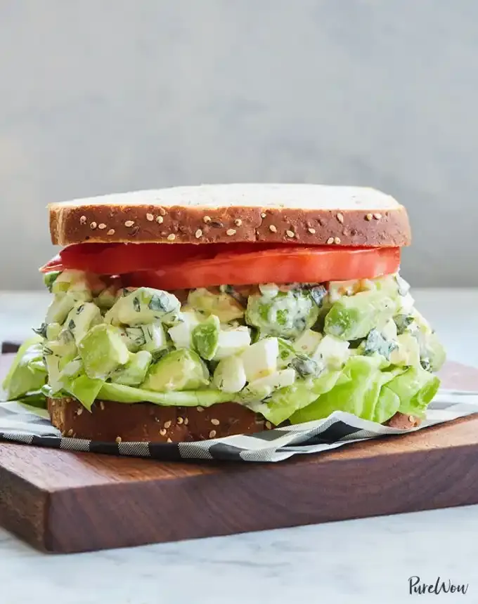 easy lunch ideas: avocado egg salad sandwich on cutting board' title='82 Easy Lunch Ideas That Are Fast Low-Fuss and Foolproof