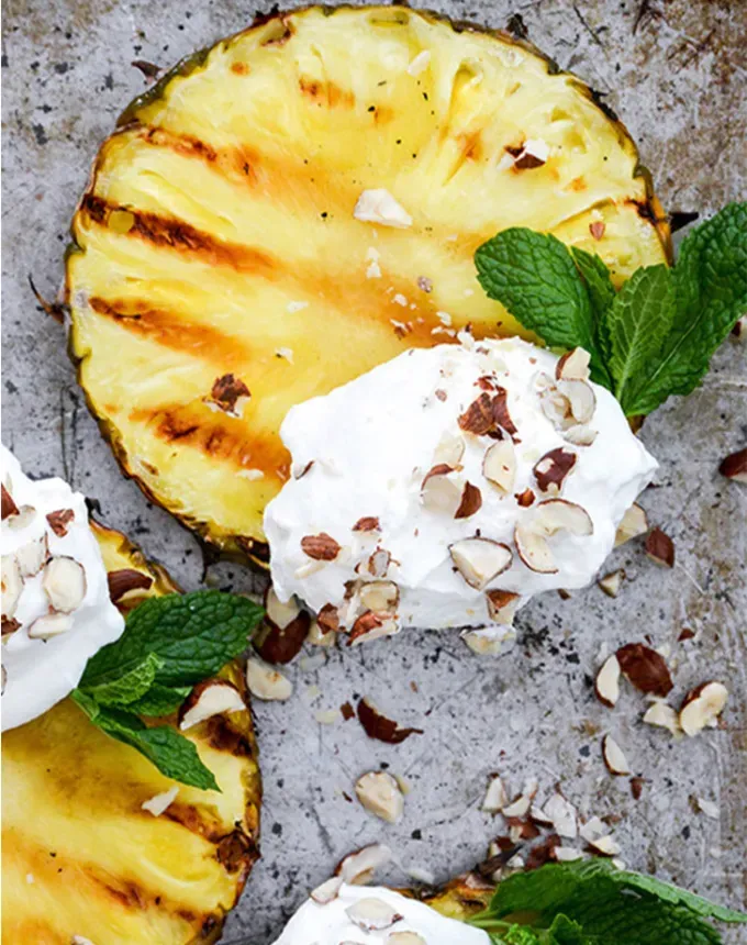 easy summer dessert recipes: grilled pineapple with coconut whip' title='92 Easy Summer Desserts to Devour from Now Until Labor Day