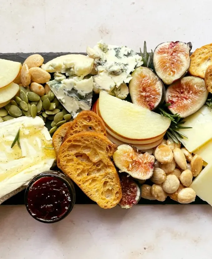 brie recipes: aerial view of fall charcuterie board with nuts figs apples cheese bread and jam' title='The 43 Most Delicious Brie Recipes That Put the Cheese Front and Center