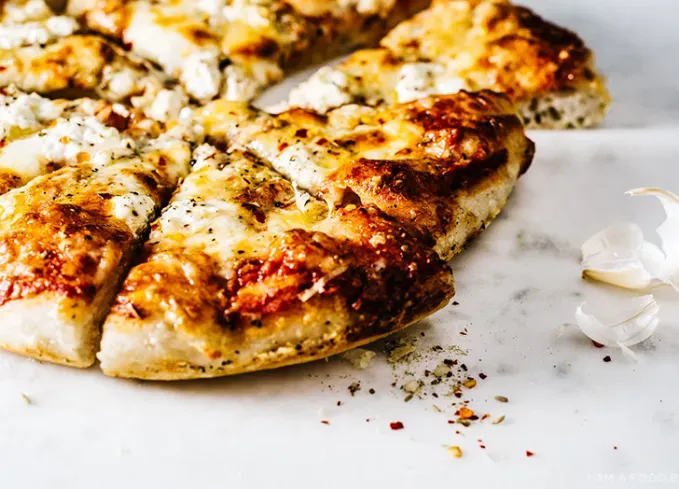 brie recipes: four-cheese pizza on a marble counter' title='The 43 Most Delicious Brie Recipes That Put the Cheese Front and Center