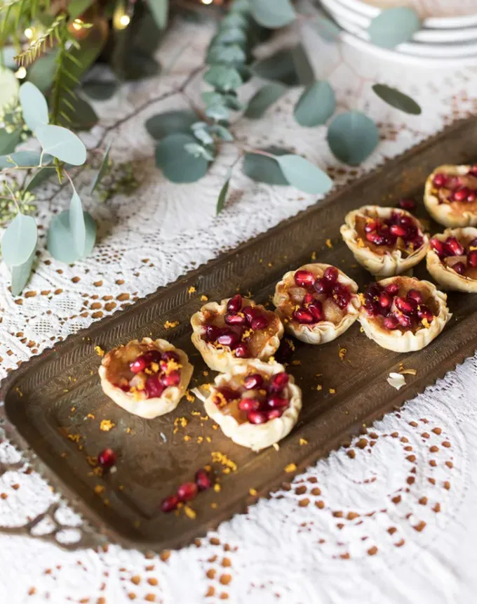 brie recipes: aerial of pear-cranberry brie tarts on a serving board' title='The 43 Most Delicious Brie Recipes That Put the Cheese Front and Center