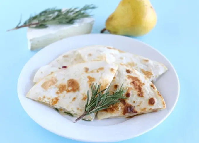 brie recipes: brie-pear quesadilla on a plate' title='The 43 Most Delicious Brie Recipes That Put the Cheese Front and Center