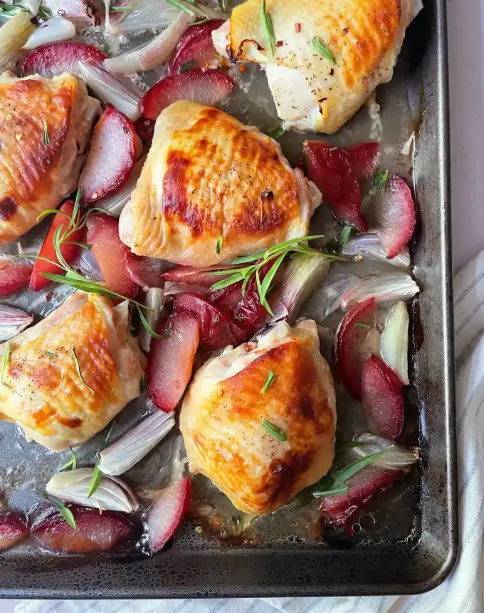 best big-batch recipes: close-up of buttermilk chicken thighs roasted with plums and red onions' title='76 Big-Batch Dishes & Recipes to Feed a Crowd