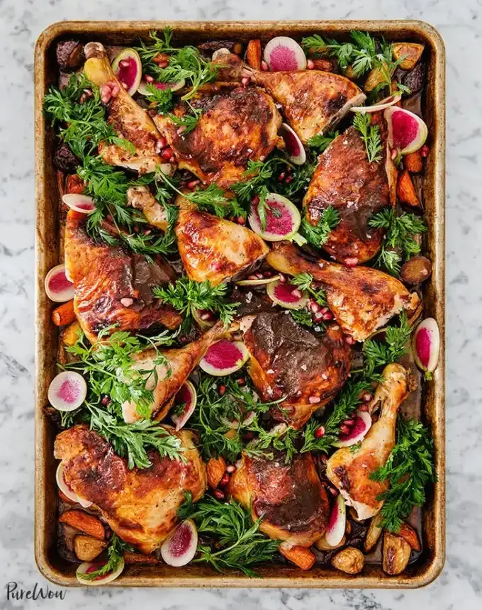 best big-batch recipes: baking sheet of roasted pomegranate chicken pieces topped with herbs and radishes' title='76 Big-Batch Dishes & Recipes to Feed a Crowd