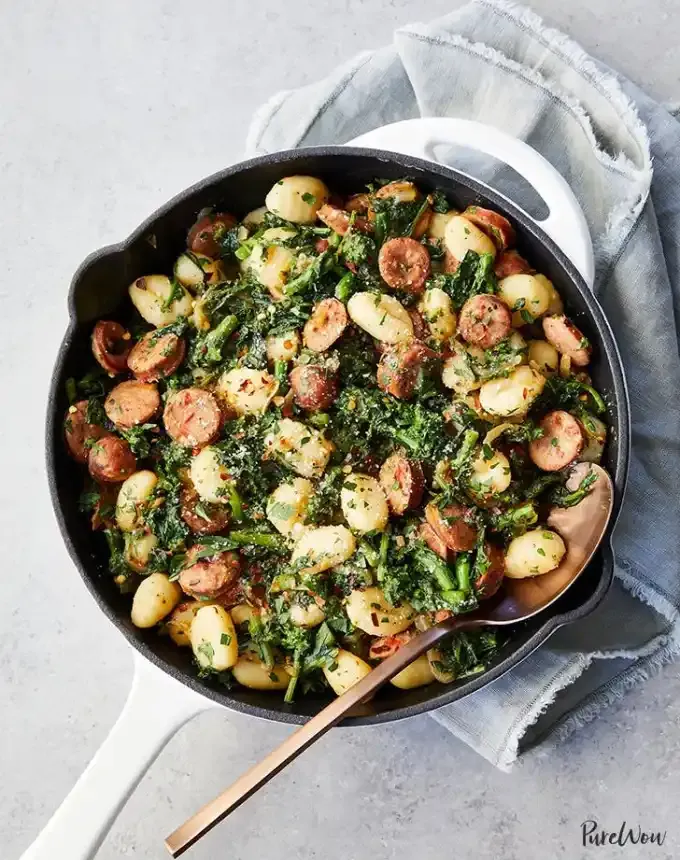 best big-batch recipes: skillet of broccoli rabe-sausage gnocchi atop a gray linen' title='76 Big-Batch Dishes & Recipes to Feed a Crowd