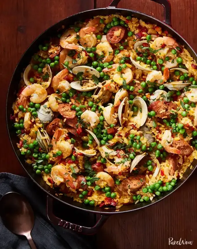 best big-batch recipes: large skillet of paella on a wooden table' title='76 Big-Batch Dishes & Recipes to Feed a Crowd