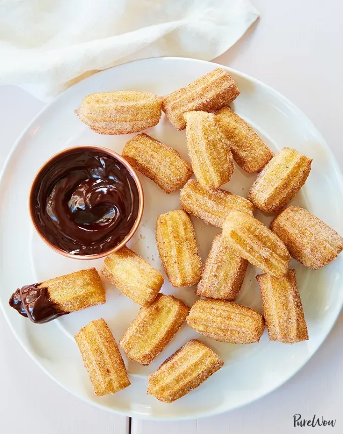 mini thanksgiving dessert recipes: churro bites with chocolate sauce' title='54 Mini Thanksgiving Desserts That Are (Almost) Too Cute to Eat