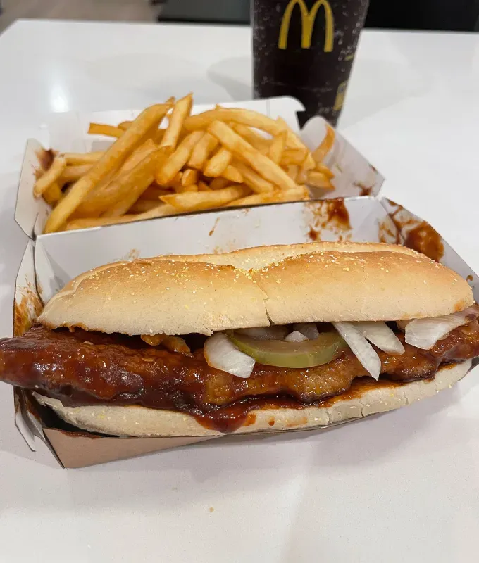 mcdonald’s mcrib review: mdonald’s mcrib with fries' fetchpriority='auto' title='The McRib Is Back for a Limited Run—Here’s a Food Editor’s Review of Her First-Ever Taste