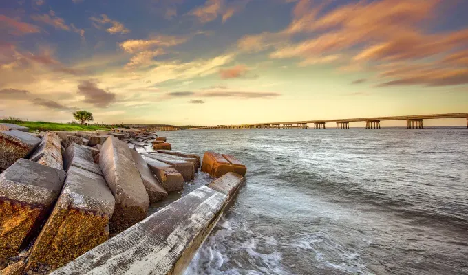 Fall Getaways in Florida - A photo of the shoreline of a rocky beach in Amelia Island at sunset.' title='The 12 Best Fall Getaways in Florida (Because There’s Way More to See Than Just Beaches)