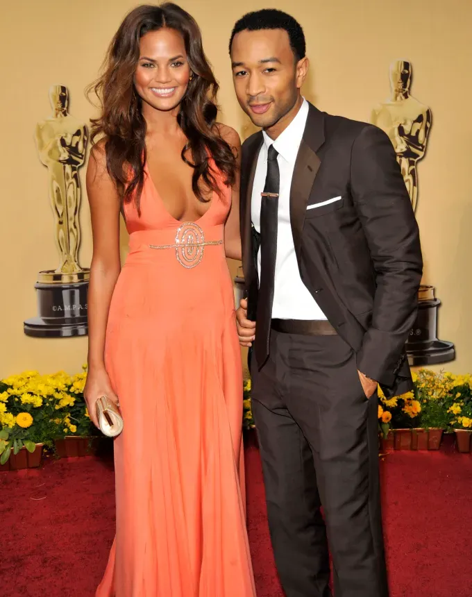 chrissy teigen john legend oscars' fetchpriority='auto' title='A Definitive Timeline of Chrissy Teigen’s Rise from ‘Deal or No Deal’ Briefcase Model to Queen of Twitter