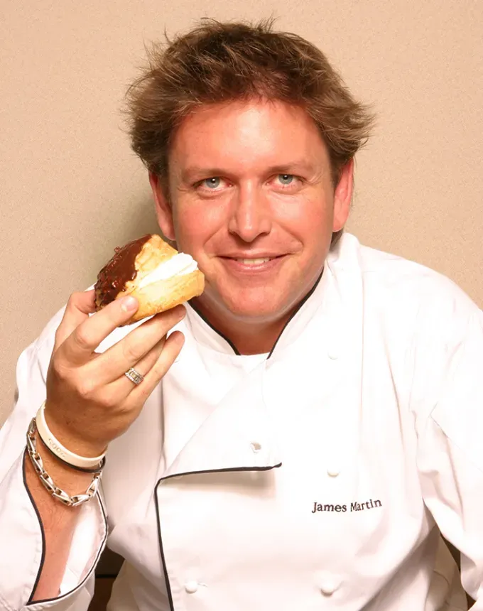 british chef james martin eating an eclaire' fetchpriority='auto' title='7 British Chefs (Who Aren’t Gordon Ramsay or Jamie Oliver) Who Should Totally Be on Your Radar