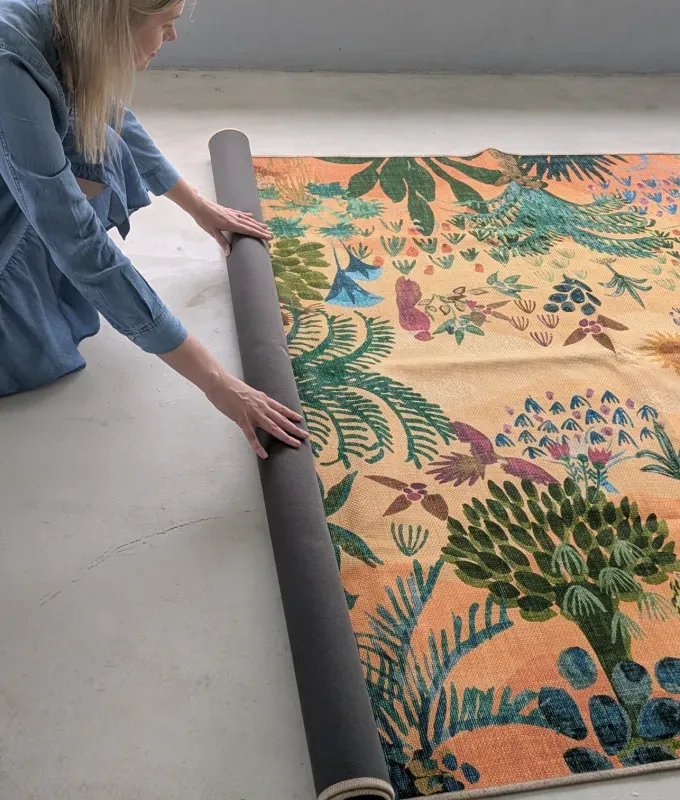 rolling out ruggable outdoor rug' title='Ruggable’s Outdoor Rugs Are Machine-Washable But That’s the Least Interesting Thing About Them