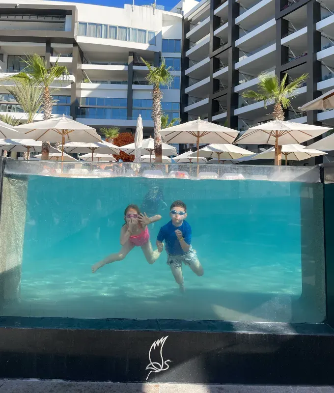the-garza-blanca-los-cabos: two children swimming in a pool.' fetchpriority='auto' title='The Garza Blanca Resort & Spa Los Cabos: An Honest Review from a Family of Four