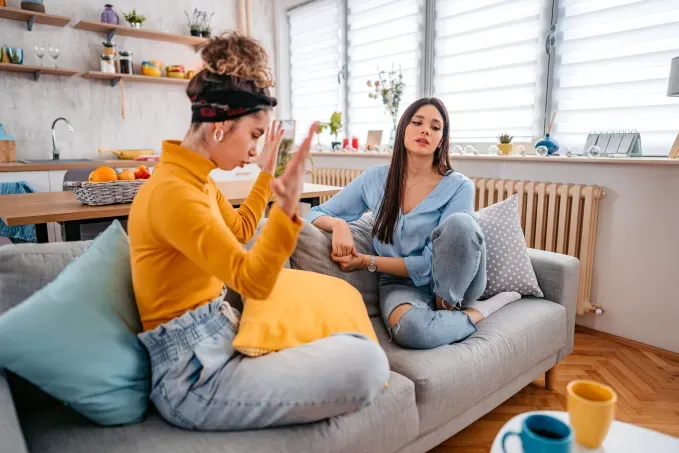 toxic sisters two women sitting on a couch in an argument' fetchpriority='auto' title='9 Signs You Might Have a Toxic Sister (& How to Cope According to Therapists)