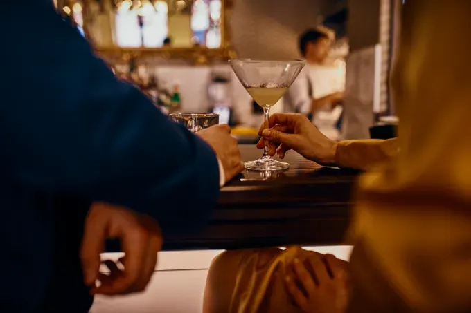 questions to ask on a first date closeup of people at a bar' fetchpriority='auto' title='10 Questions to Ask on a First Date According to a Matchmaker